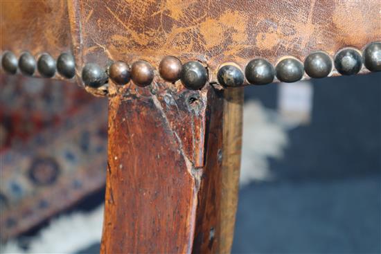 A George III mahogany hide-covered wing chair